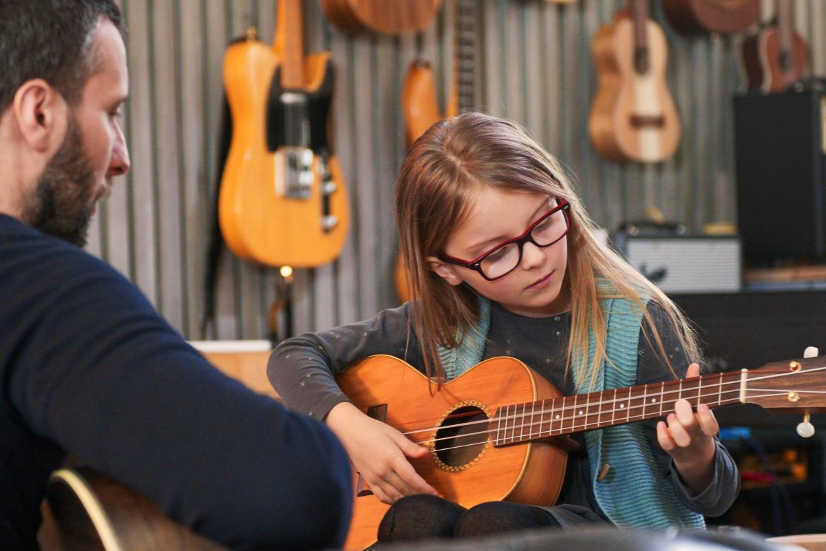 A child taking private Ukulele lessons with a teacher